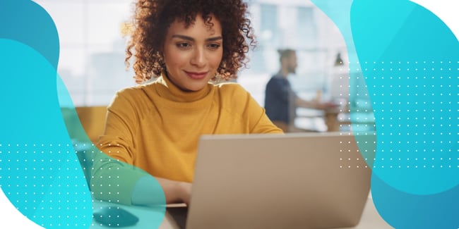 Professional woman with curly hair looking at laptop