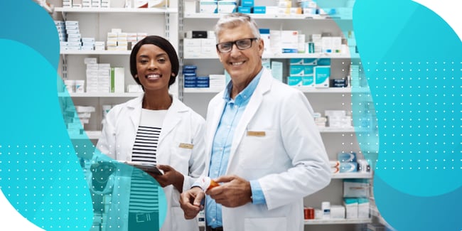 Two pharmacists smile in a well-stocked pharmacy, representing efficient supply management in clinical trials. This setting symbolizes the benefits of the new free picking feature in Signant's SmartSignals RTSM, which optimizes medication distribution, reduces waste, and enhances trial efficiency.