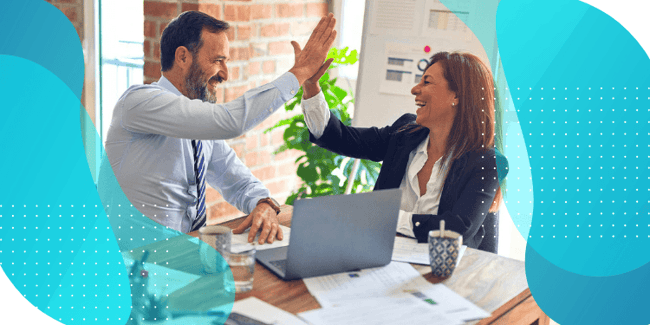 Two people high-fiving while working together on a computer, symbolizing collaboration and success in utilizing Signant SmartSignals® Marketplace to enhance clinical trial management through seamless integration and improved data quality.