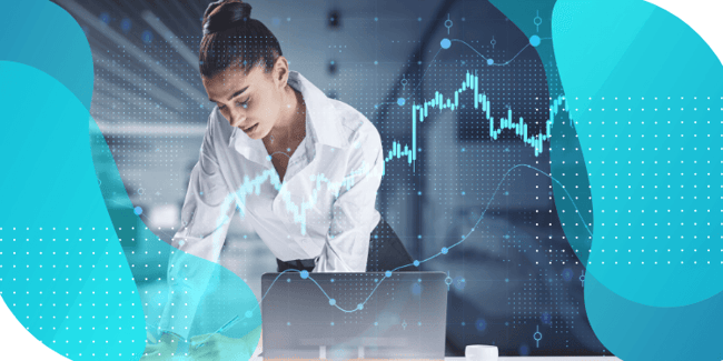 A woman working on a computer with surrounding graphs, illustrating efficient clinical forecasting and supply planning using advanced trial supply management solutions.